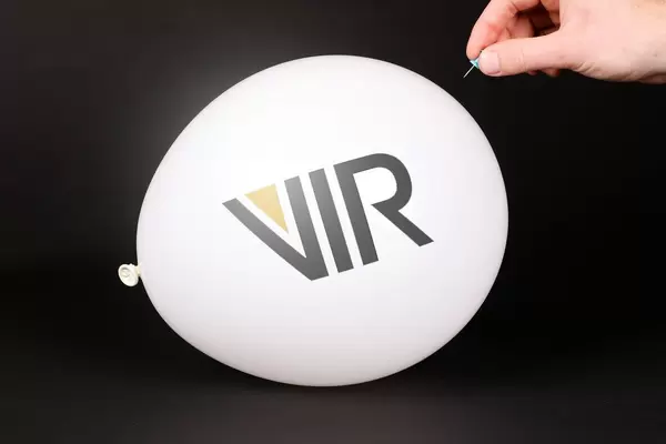 Hand uses a needle to burst a balloon with Vir Biotechnology logo