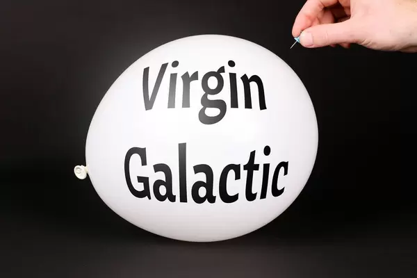 Hand uses a needle to burst a balloon with Virgin Galactic text