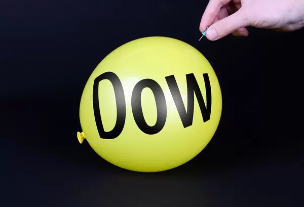 Hand uses a needle to burst a yellow balloon with Dow text