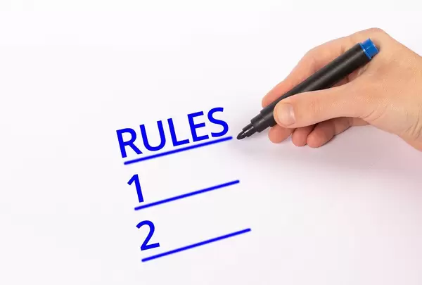 Hand with blue marker writing list of rules