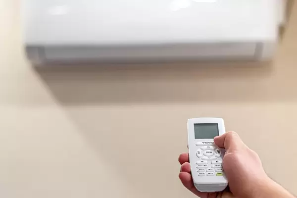 Hand with remote control directed on the conditioner (Flip 2020)