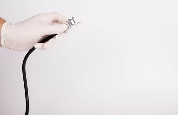 Hand with stethoscope on white background