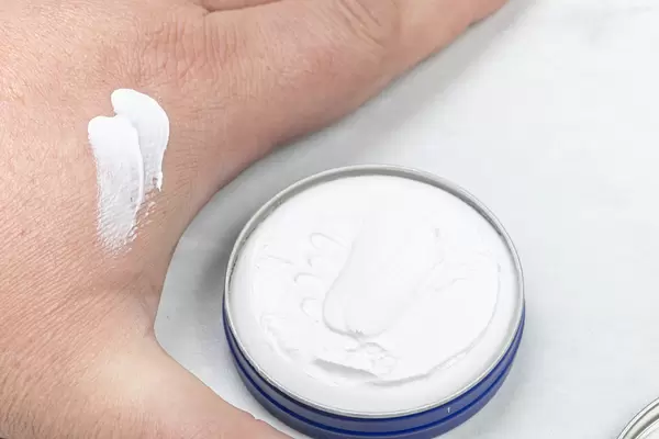 Hand with white cream and healthy concept above white background