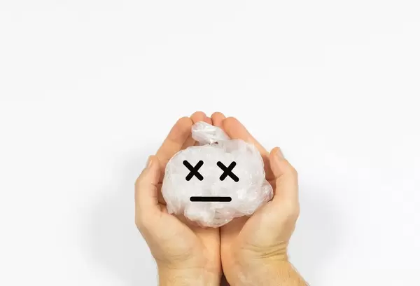 Hände die eine zerknüllte Plastiktüte halten als Darstellung des Plastiksproblems