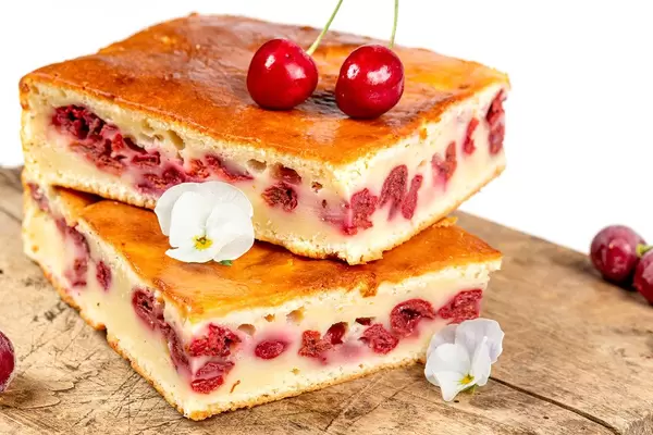 Handgemachte Tarte mit Kirschen auf einem Schneidebrett: Nahaufnahme vor weißem Hintergrund