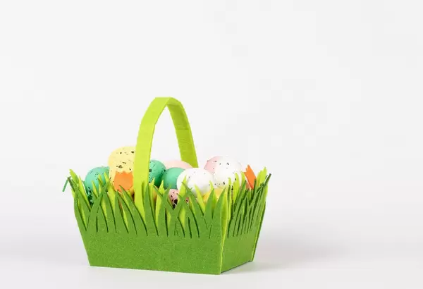 Handgemachter Osterkorb aus grünem Filz mit Tulpen verziert und mit farbigen Ostereiern gefüllt