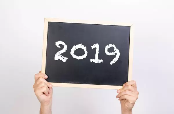 Hands holding blackboard with 2019 text