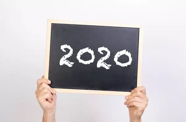 Hands holding blackboard with 2020 text