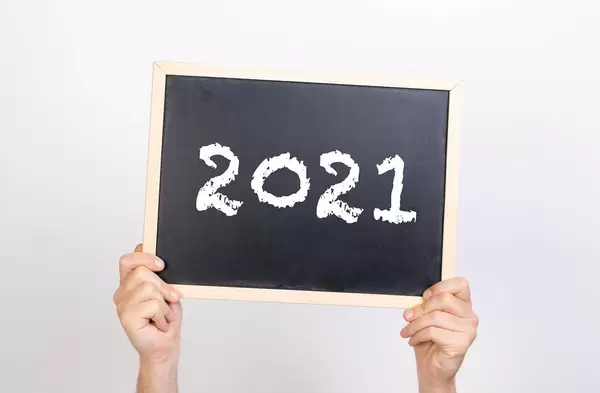 Hands holding blackboard with 2021 text