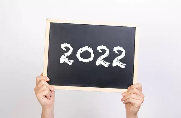 Hands holding blackboard with 2022 text
