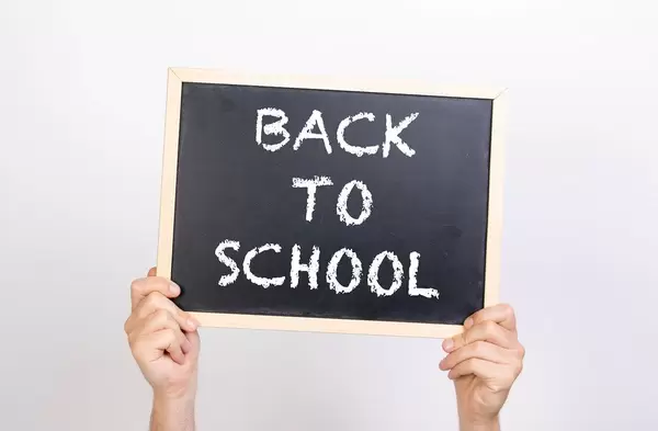Hands holding blackboard with text Back to school