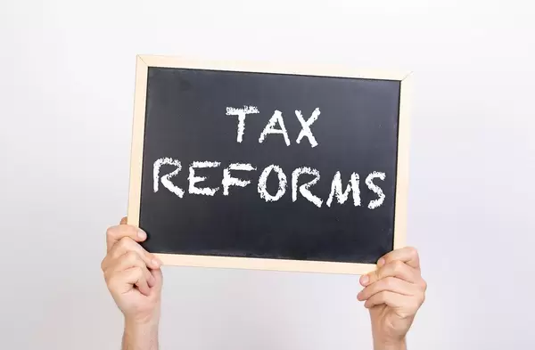 Hands holding blackboard with text Tax reform