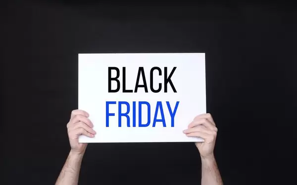 Hands holding board with Black Friday text against black background.jpg