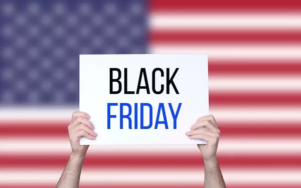 Hands holding board with Black Friday text with USA flag background
