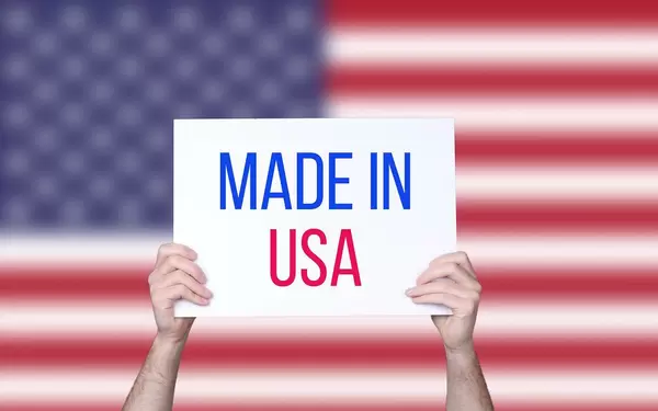 Hands holding board with Made in USA text with USA flag background.jpg