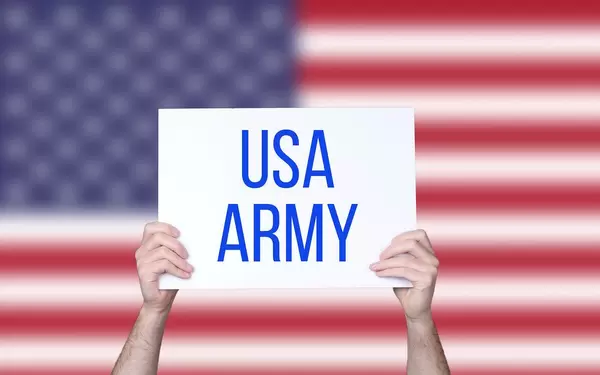 Hands holding board with USA Army text with USA flag background.jpg