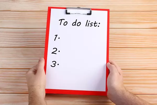 Hands holding clipboard with To do list