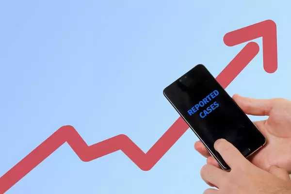 Hands holding mobile phone with Reported Cases text