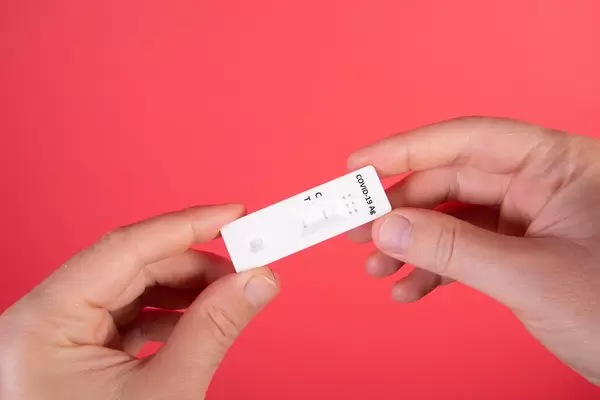 Hands holding rapid covid -19 test with a negsative result