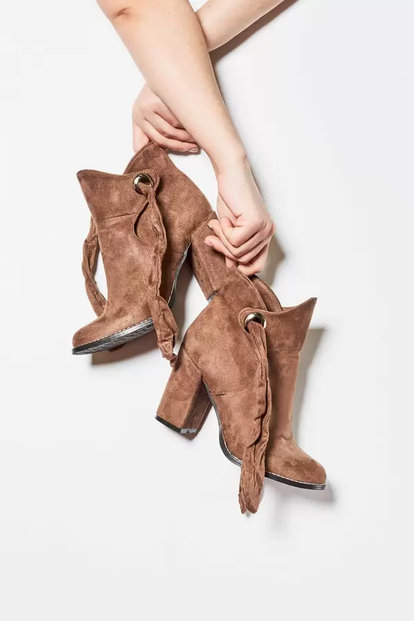 Hands holding stylish leather footwear against the white background