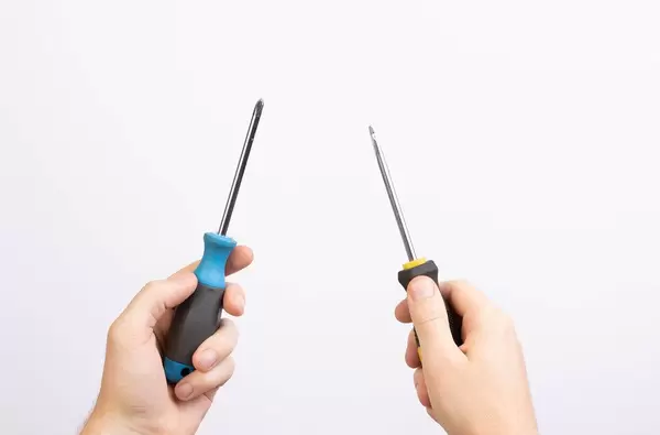 Hands holding two screwdrivers