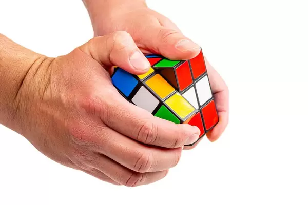 Hands of a man with a Rubik's Cube. Puzzle concept, problem solving