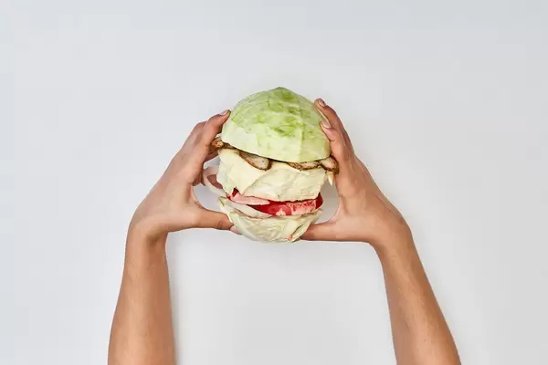Hands of a person eating homemade vegetable hamburger