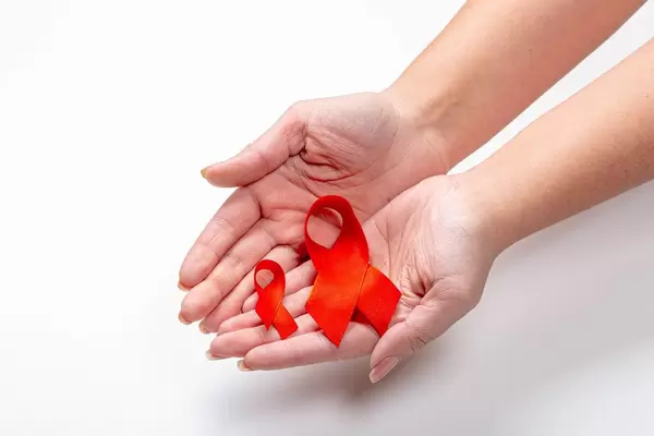 Hands of a woman holding two ribbons as a symbol of the fight and prevention of cancer