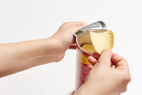 Hands taking out and eating chips