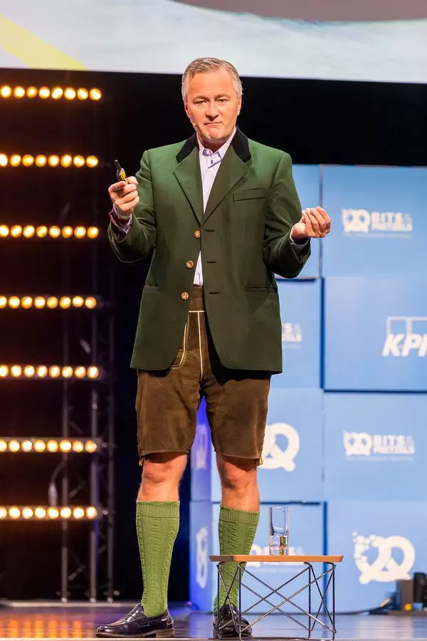 Hannes Ametsreiter von Vodafone Deutschland hält eine Rede in Lederhosen und gestikuliert auf der Bühne von Gründerkonferenz Bits & Pretzels in München