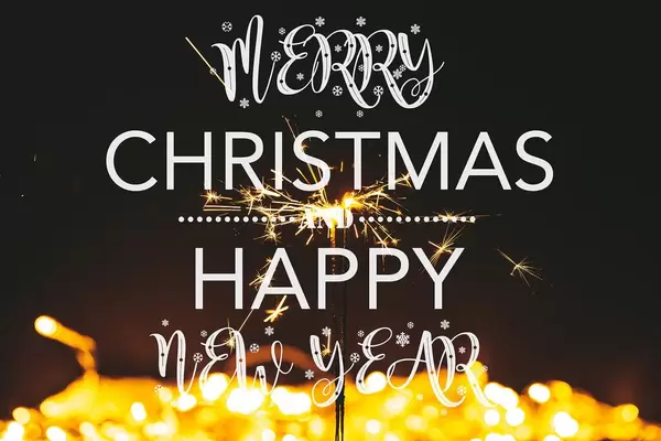 Happy Christmas and New Year on golden bokeh background with sparklers