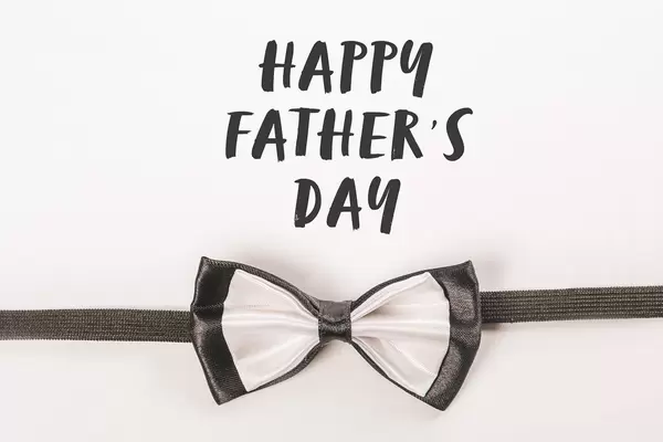 Happy father day inscription on a white background with a bow tie