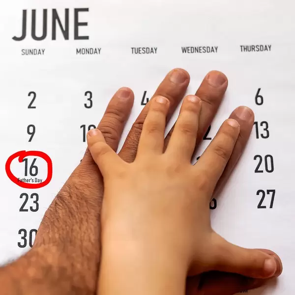 Happy Father's Day concept. 16 June 2019. Father and his son putting their hands on the calendar.