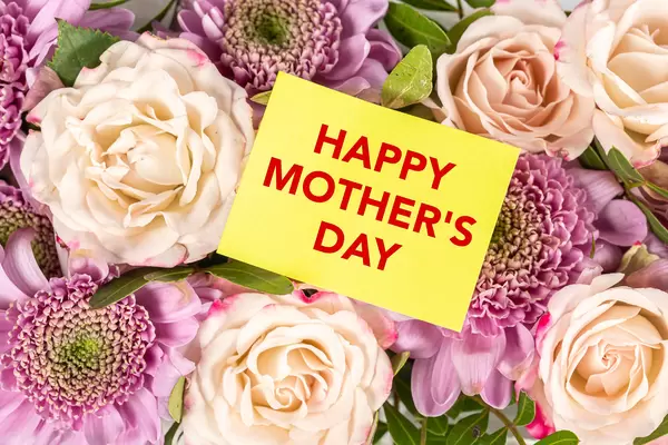 Happy mothers day greeting card on flowers background, top view