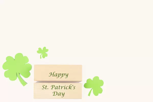 Happy st patrick's day wooden blocks with paper clover leaves