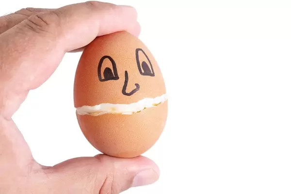 Hard Boiled Egg with eyes and smile in the hand
