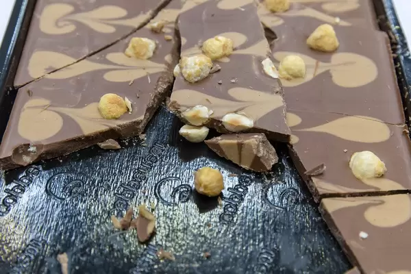 Haselnuss und Karamellschokolade auf schwarzem Probiertablett auf dem BarCamp in Bonn