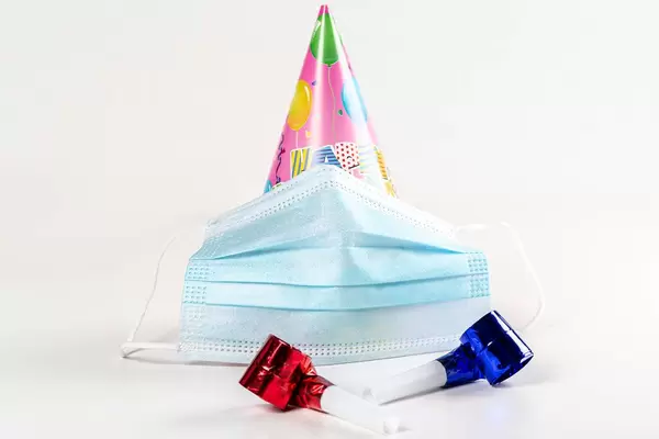 Hat in the form of a cone with medical mask. Birthday celebration during quarantine