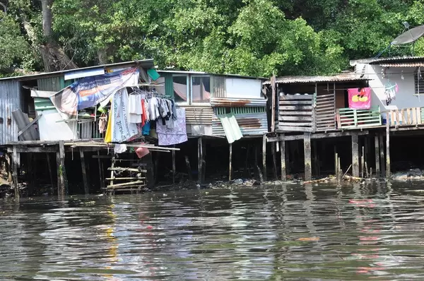 Häuser auf Stelzen im verschmutzten Wasser - Thailand