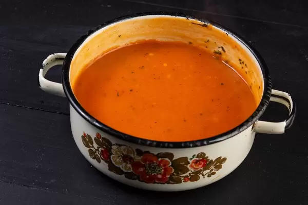 Hausgemachte Tomatensauce in altem, rustikalen Kochtopf mit Blumen verziert