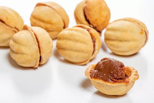 Hausgemachte Walnusskekse mit Karamellfüllung auf weißem Tisch