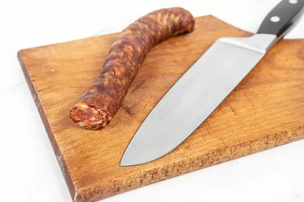 Hausgemachte Wurst aus heimischem Schweinefleisch, neben einem Küchenmesser