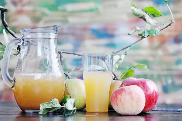 Hausgemachter Apfelsaft mit Äpfeln auf dem Tisch