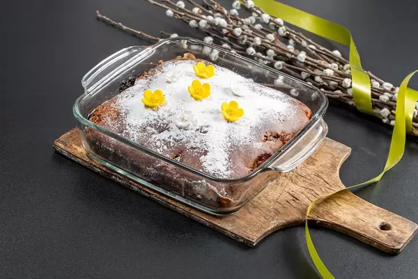 Hausgemachter, frischgebackener Kirschkuchen mit Puderzucker vor schwarzem Hintergrund