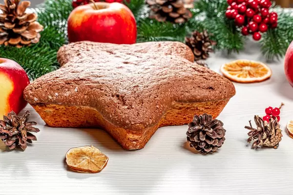 Hausgemachter sternförmiger Biskuitkuchen auf Weihnachtshintergrund