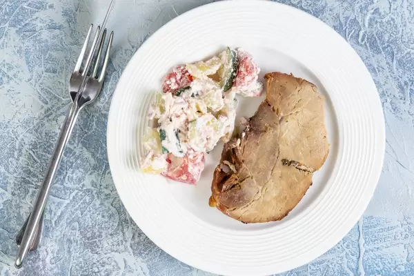 Hausgemachtes serbisches Gericht aus Schweinefleisch und Schopska-Salat aus Gemüse