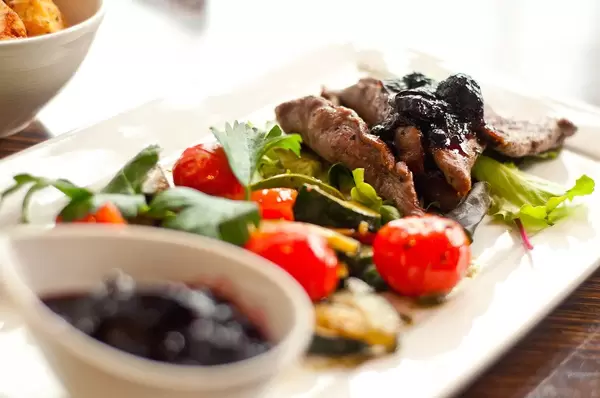 Having lunch in a restaurant: plate with vegetables and meat