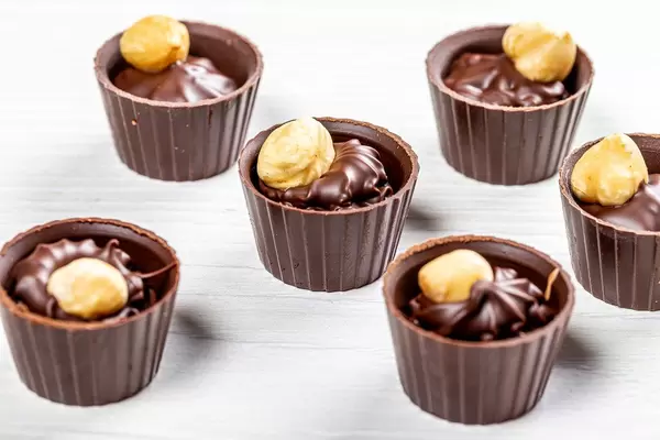 Hazelnut and milk chocolate candies on white wooden background (Flip 2019)