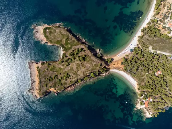 Headland forming a bay and separating two beaches: drone photo of the cliff at Kokkinokastro, Alonnisos