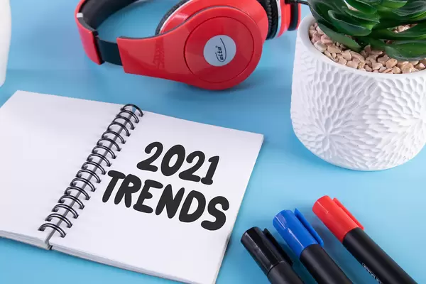 Headphones, flower and notebook with 2021 Trends text